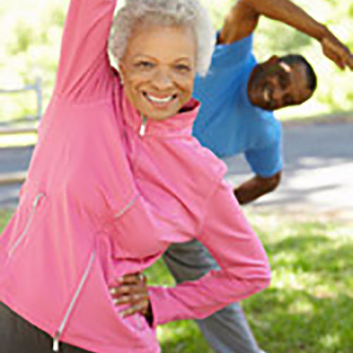 Senior African American Couple Exercising In Park
